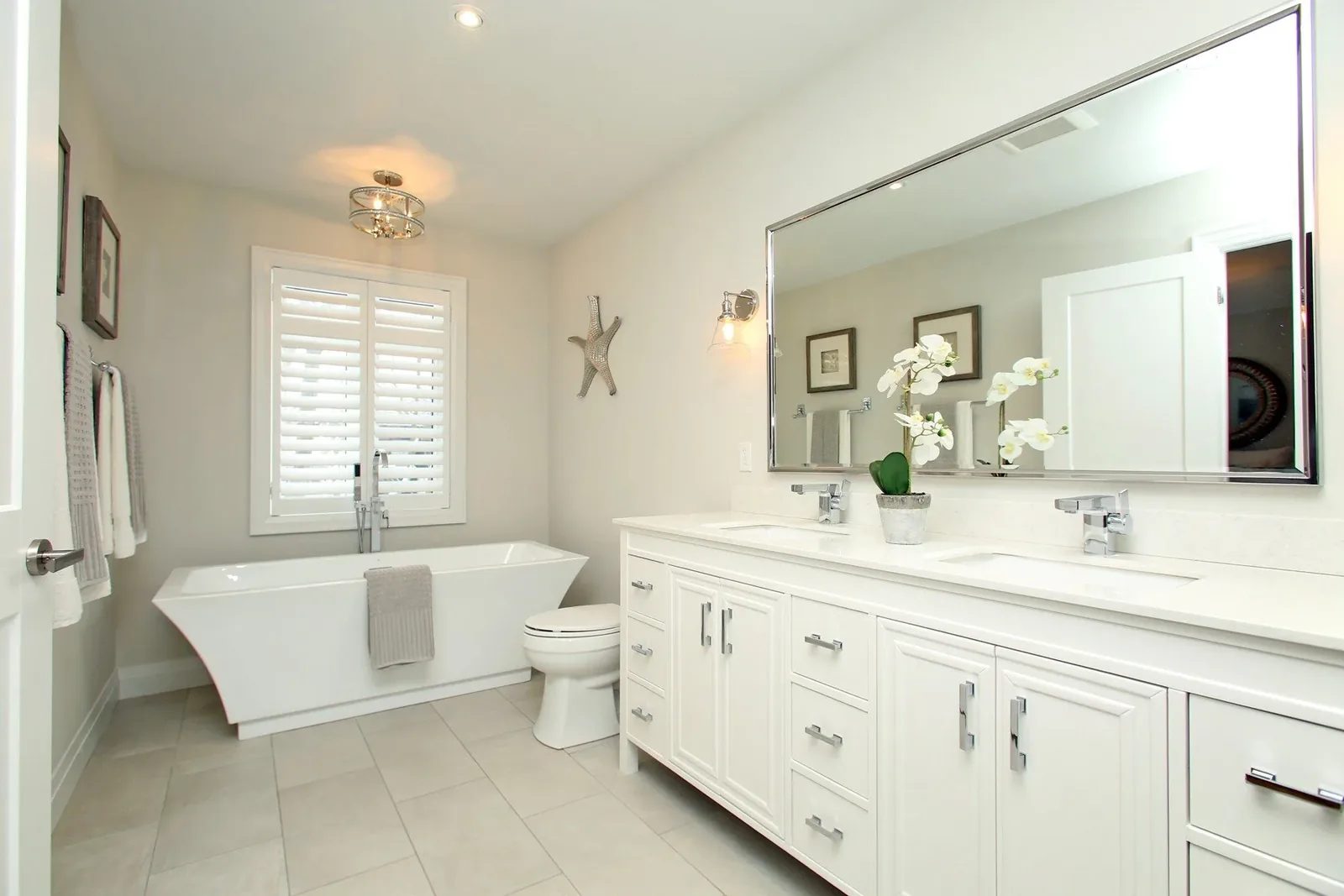 Bright renovated bathroom with a double vanity, freestanding tub and soft neutral colour palette.