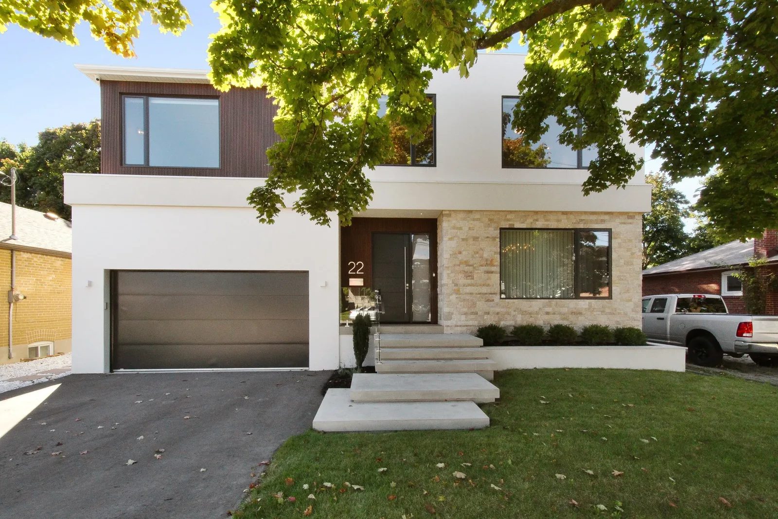 Symmetrical front elevation featuring stacked stone cladding and large metallic number 22 by the entry.