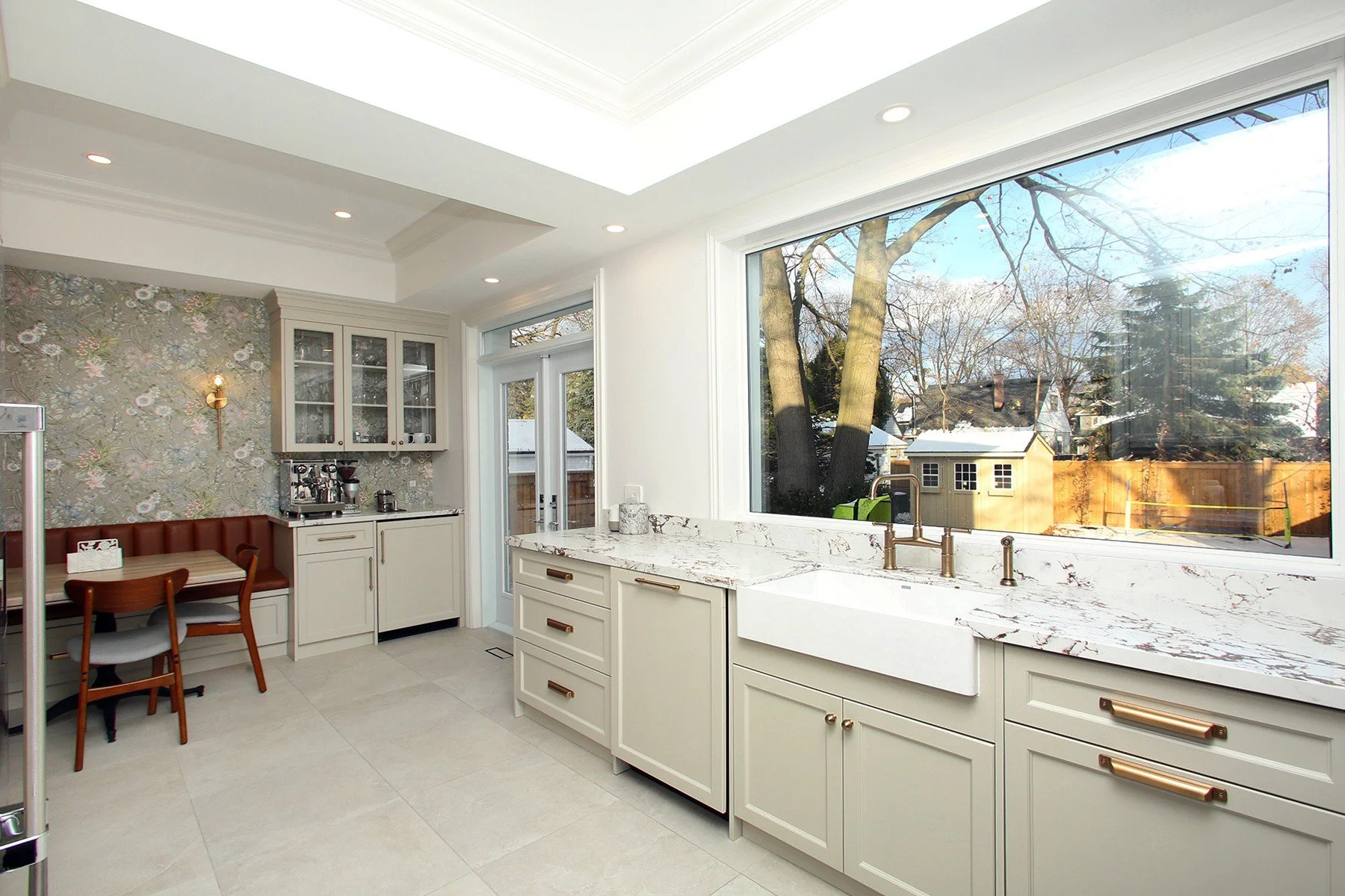 Bright renovated kitchen with warm white cabinetry, quartz counters and a cosy breakfast nook.
