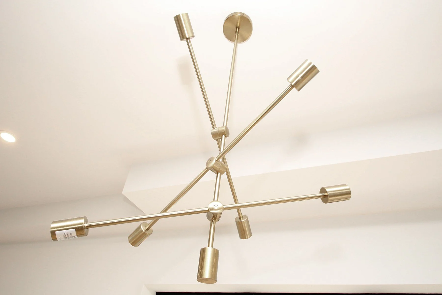 Brushed brass ceiling light adds warm colour against a clean white finished ceiling.