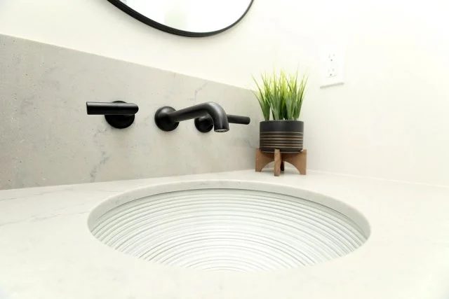 Matte black wall-mounted faucet over a patterned undermount basin, Timeless Elegance project