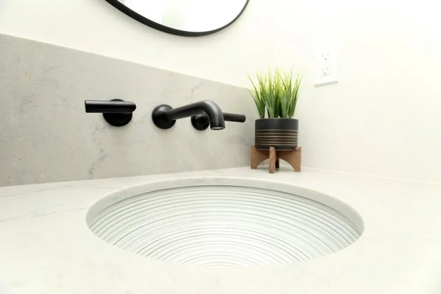 Matte black wall-mounted faucet over a patterned undermount basin, Timeless Elegance project