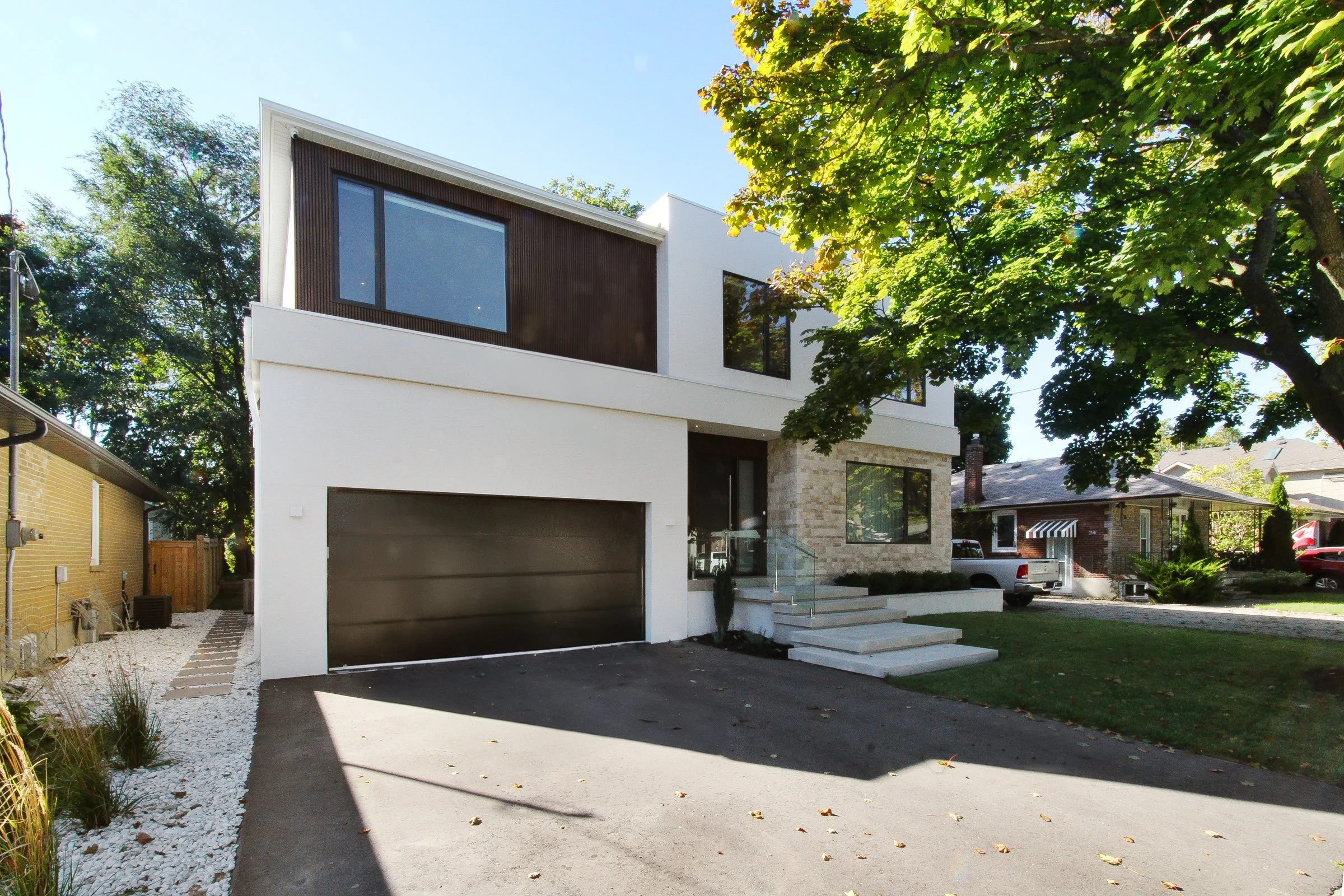 Straight on exterior of the modern two storey home showing the cantilevered wood-clad upper volume.