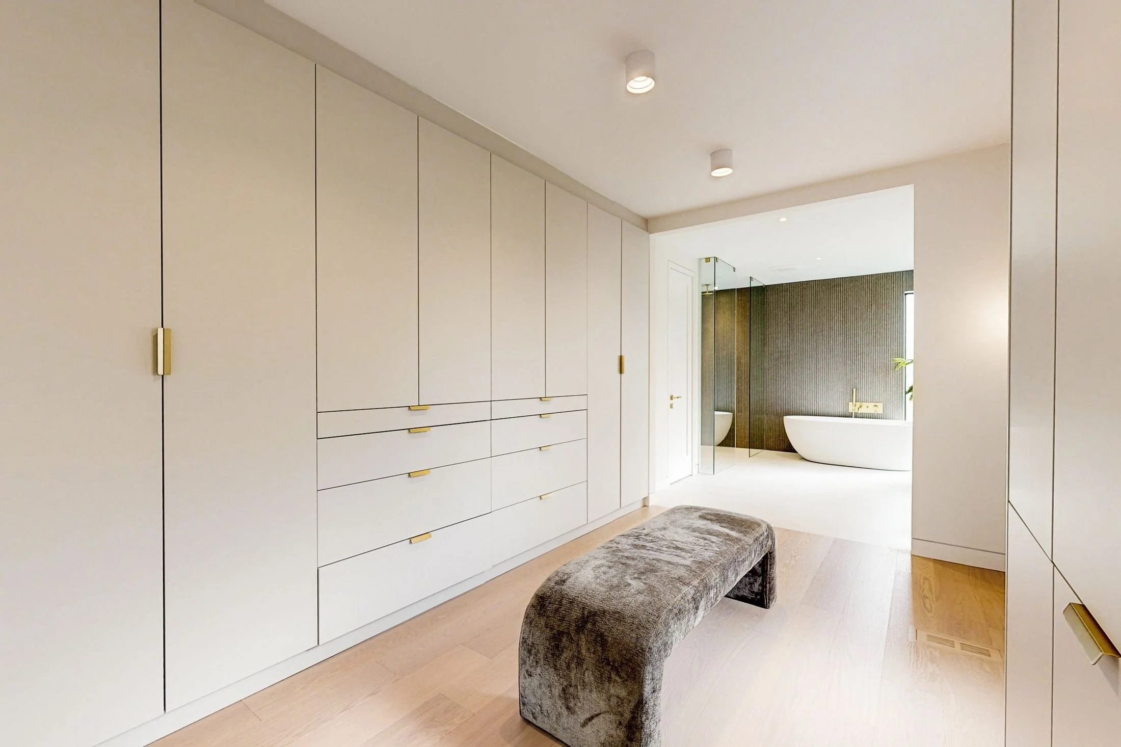 After renovation, custom wardrobe wall in the primary dressing area.