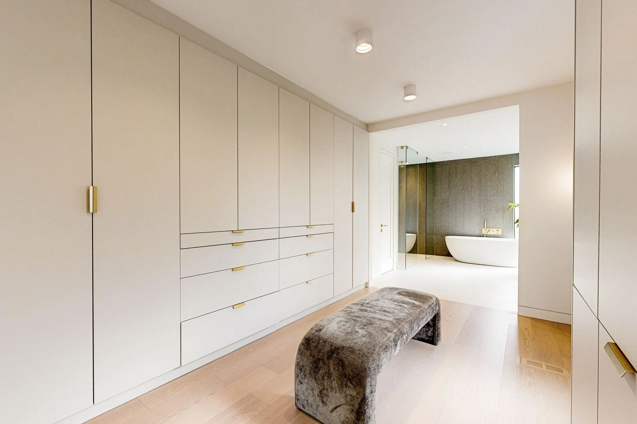 After renovation, custom wardrobe wall in the primary dressing area.