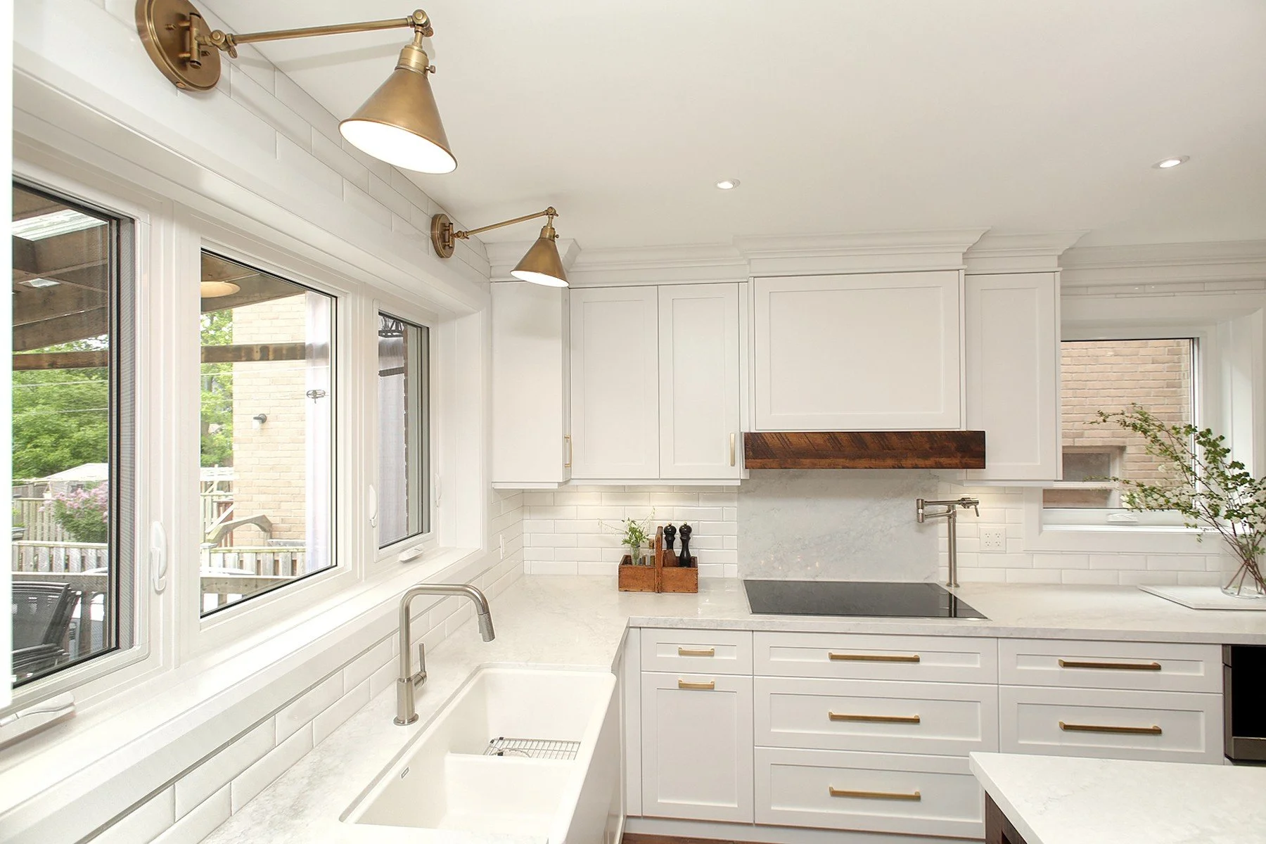 Modern kitchen with white cabinets, brass hardware, and subway tile backsplash.