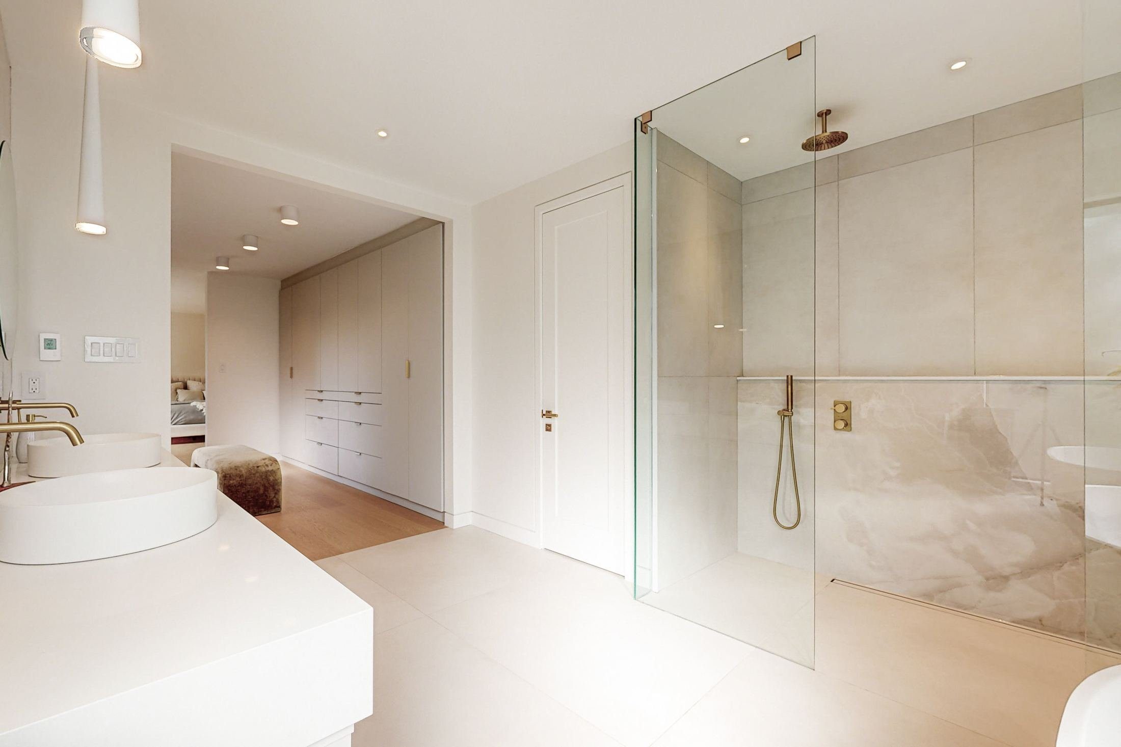 Completed custom build in Etobicoke showing open kitchen with marble island and brass details.